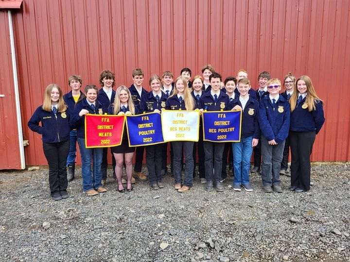FFA students holding blue white and red banners in from on red building