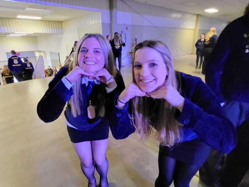 two ffa students in uniform posing for picture